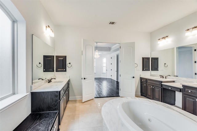 bathroom featuring tile patterned floors, vanity, and tiled tub