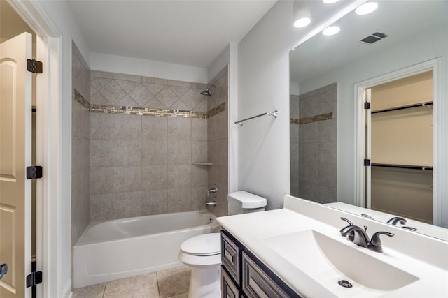 full bathroom featuring tile patterned flooring, vanity, tiled shower / bath combo, and toilet