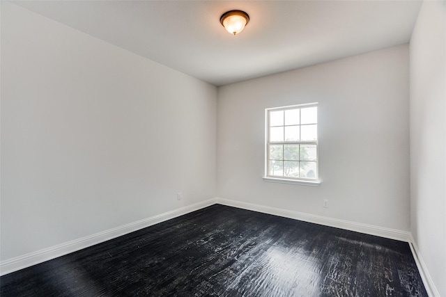 unfurnished room with dark hardwood / wood-style flooring