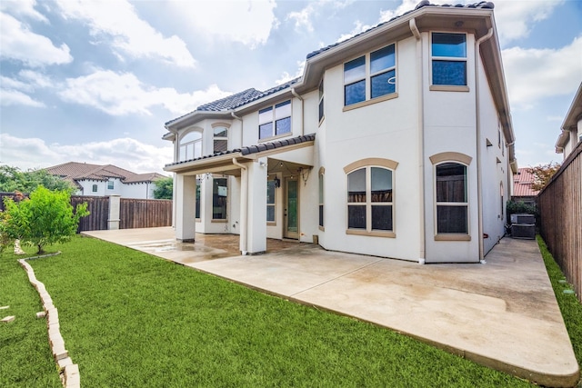 back of property with a yard, a patio, and central air condition unit