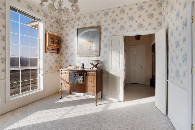 hallway with an inviting chandelier, carpet floors, and a wealth of natural light