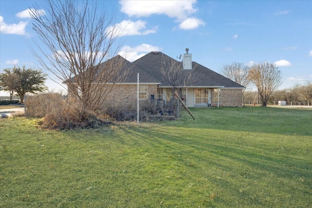 rear view of house featuring a lawn