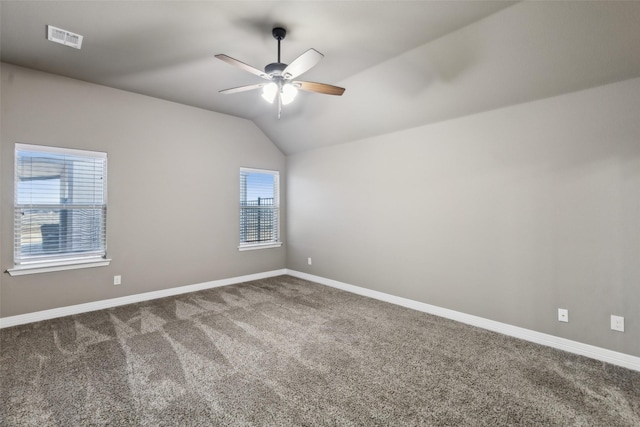 carpeted empty room with vaulted ceiling and ceiling fan