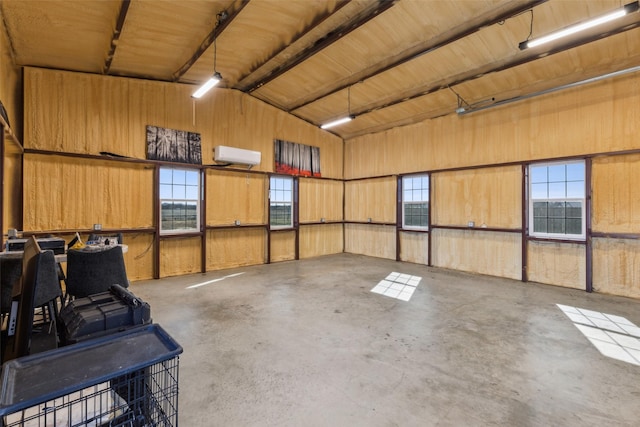 garage featuring wooden walls and a wall unit AC