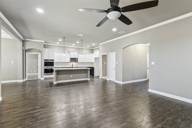 unfurnished living room with crown molding, ceiling fan, dark hardwood / wood-style floors, and sink