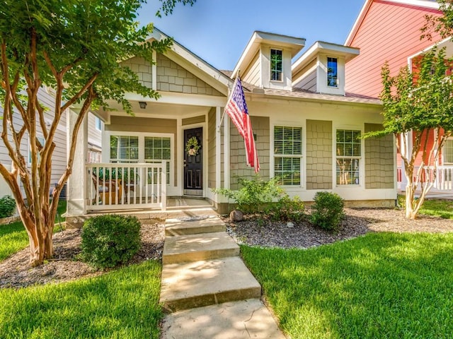 view of front of property featuring a front yard and covered porch