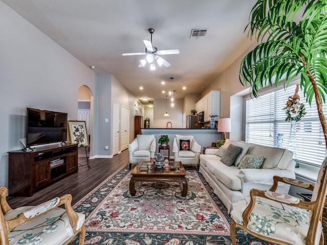 living room with dark wood-type flooring and ceiling fan