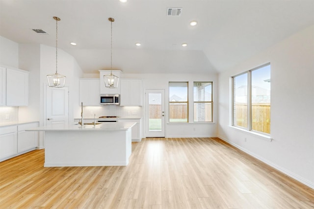 5208 Greenbrook Rd, Denton, TX 76226 - kitchen with stainless steel microwave, a sink, vaulted ceiling, light countertops, and backsplash