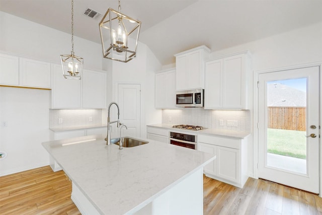 5208 Greenbrook Rd, Denton, TX 76226 - kitchen with stainless steel appliances, a sink, a chandelier, vaulted ceiling, and a kitchen island with sink