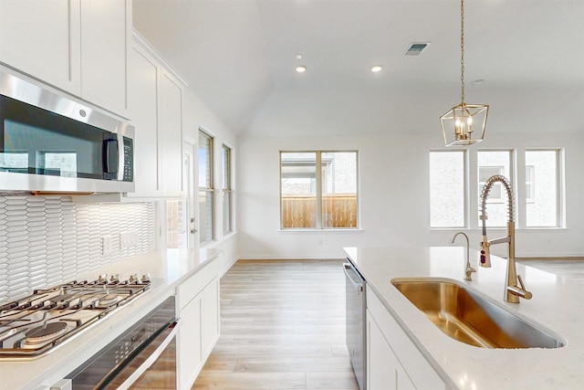 5208 Greenbrook Rd, Denton, TX 76226 - kitchen with stainless steel appliances, a sink, decorative backsplash, light wood-style floors, and white cabinetry
