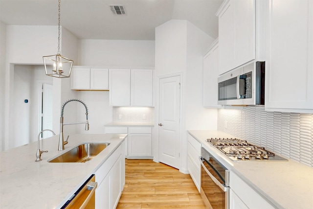 5208 Greenbrook Rd, Denton, TX 76226 - kitchen featuring stainless steel appliances, a sink, light wood-style flooring, and white cabinets