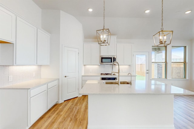 5208 Greenbrook Rd, Denton, TX 76226 - kitchen with stainless steel microwave, a chandelier, light wood-style floors, decorative backsplash, and recessed lighting