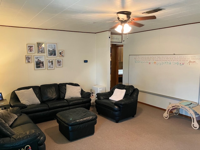 living room with ceiling fan, ornamental molding, and carpet flooring