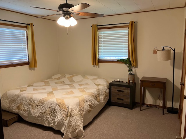 bedroom featuring ceiling fan, ornamental molding, and light carpet
