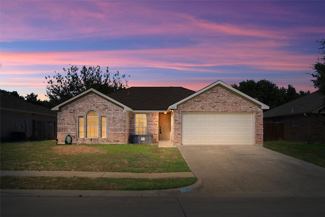 single story home featuring a garage and a lawn