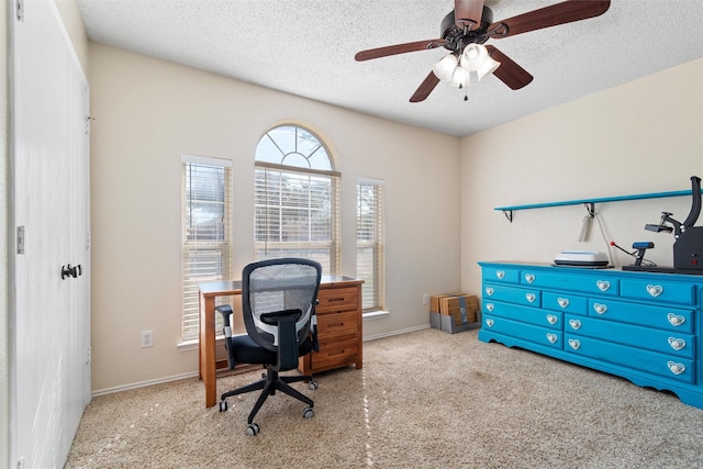 home office featuring ceiling fan, light carpet, and a textured ceiling