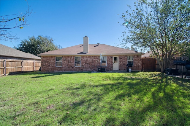 rear view of property featuring a yard