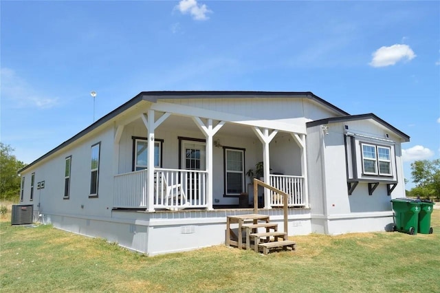 view of front facade featuring cooling unit, covered porch, and a front lawn