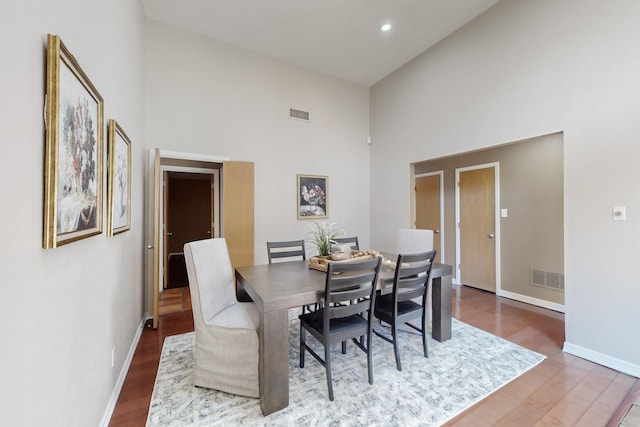 dining room featuring wood-type flooring and high vaulted ceiling