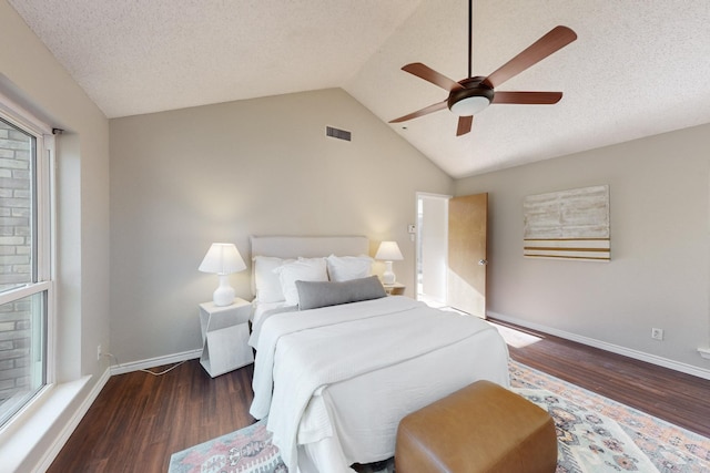 bedroom with ceiling fan, lofted ceiling, dark hardwood / wood-style flooring, and a textured ceiling