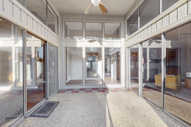 unfurnished sunroom with ceiling fan