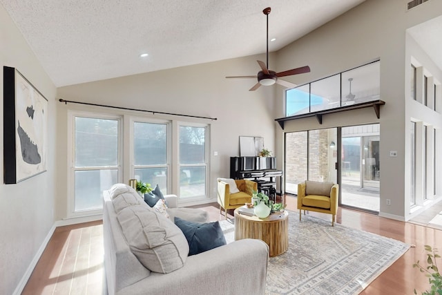 living room with ceiling fan, light hardwood / wood-style floors, and a textured ceiling