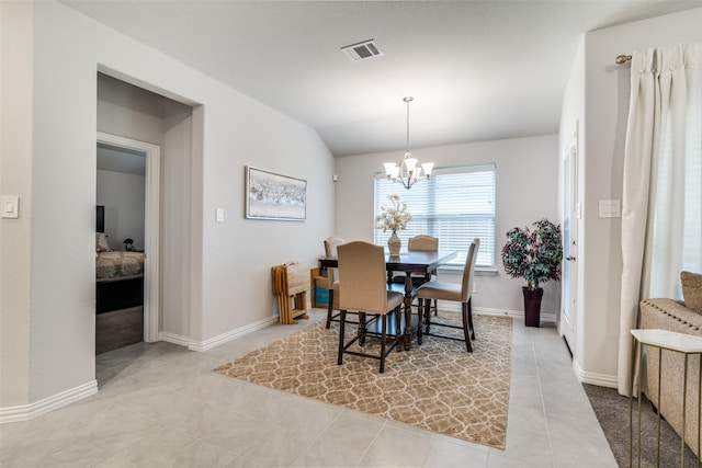 tiled dining area featuring an inviting chandelier and vaulted ceiling