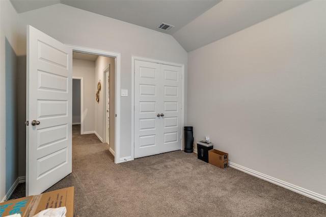 carpeted bedroom featuring vaulted ceiling and a closet