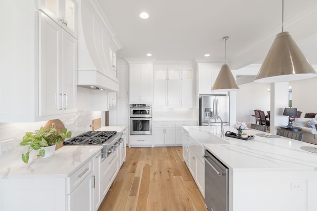 kitchen featuring white cabinets, stainless steel appliances, light wood finished floors, decorative backsplash, and premium range hood