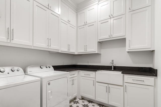 clothes washing area with cabinets, washer and dryer, and sink