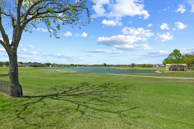 view of community with view of golf course, a yard, and a water view