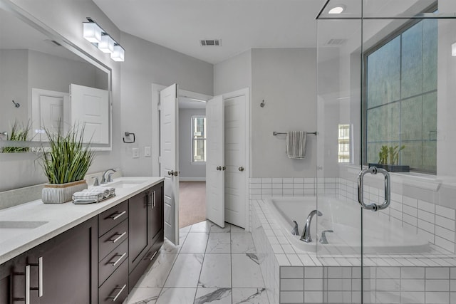 bathroom with vanity and tiled bath