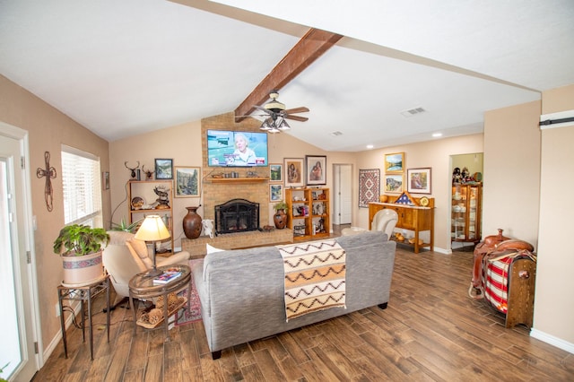 living room featuring ceiling fan, hardwood / wood-style floors, vaulted ceiling with beams, a brick fireplace, and a barn door