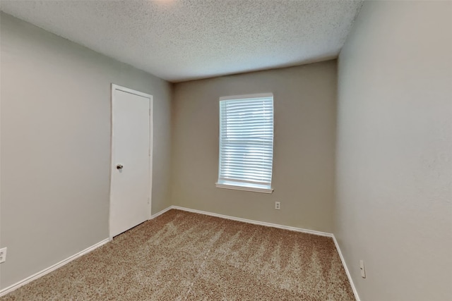 carpeted empty room featuring a textured ceiling