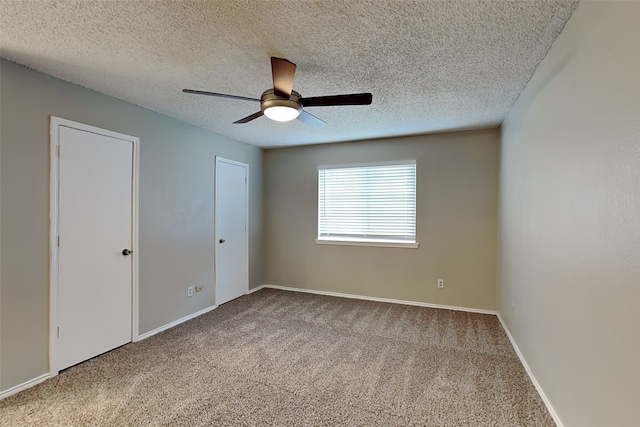 carpeted spare room featuring ceiling fan and a textured ceiling