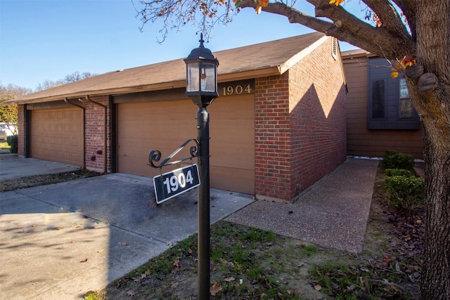 view of property exterior with a garage and brick siding