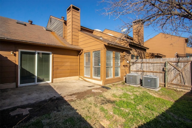 back of house featuring a yard, central AC, and a patio