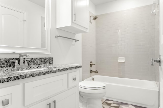 full bathroom featuring tiled shower / bath, vanity, and toilet