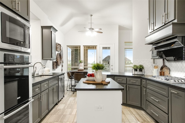 kitchen with sink, gray cabinetry, stainless steel appliances, a center island, and decorative backsplash