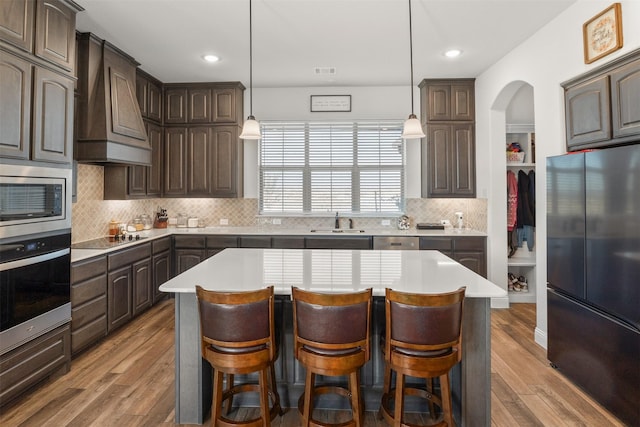 kitchen featuring dark brown cabinets, a center island, and appliances with stainless steel finishes