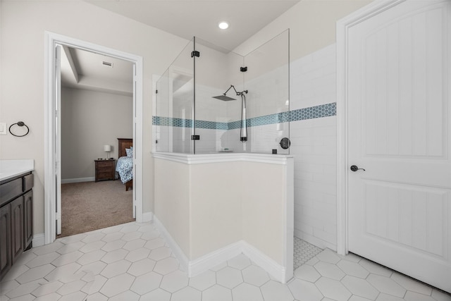 bathroom featuring vanity, tile patterned flooring, and a tile shower