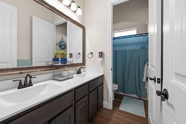 bathroom with hardwood / wood-style flooring, vanity, a shower with curtain, and toilet