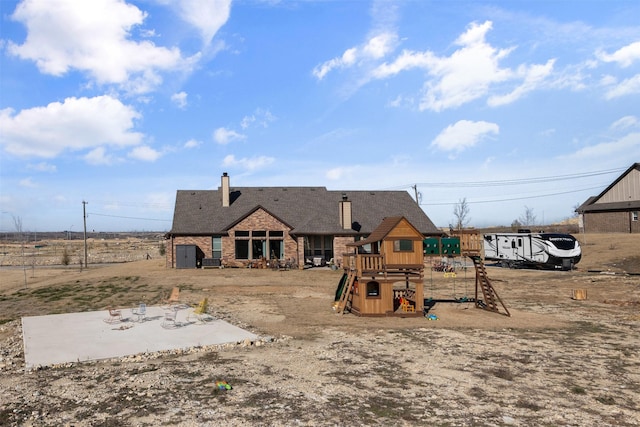 rear view of house featuring a playground