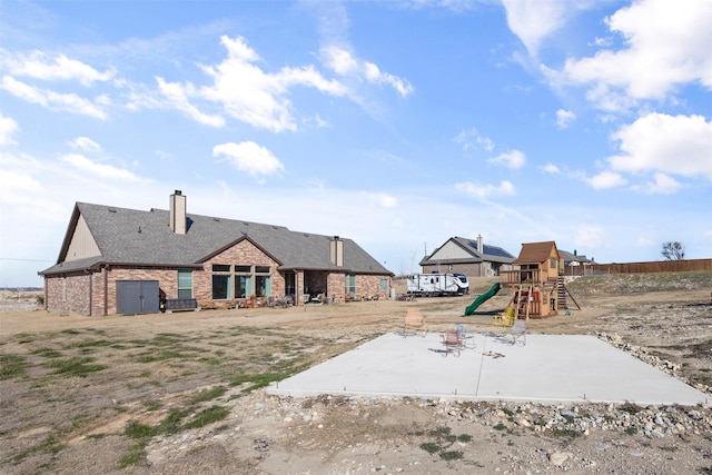 exterior space featuring a playground and a patio area