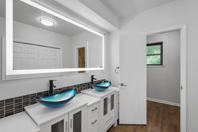 bathroom with vanity, hardwood / wood-style floors, and backsplash