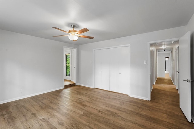 unfurnished bedroom featuring dark wood-type flooring and ceiling fan