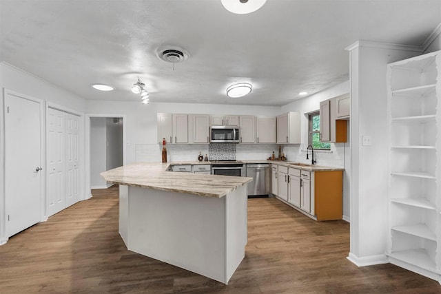 kitchen with appliances with stainless steel finishes, sink, dark hardwood / wood-style floors, and kitchen peninsula