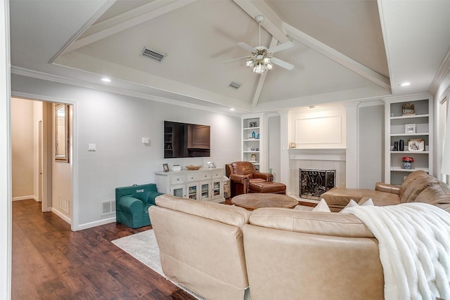 living room featuring vaulted ceiling, a tile fireplace, built in features, dark hardwood / wood-style flooring, and ceiling fan