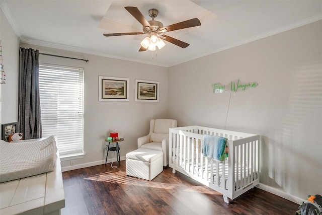 bedroom featuring ceiling fan, dark hardwood / wood-style floors, multiple windows, and a crib