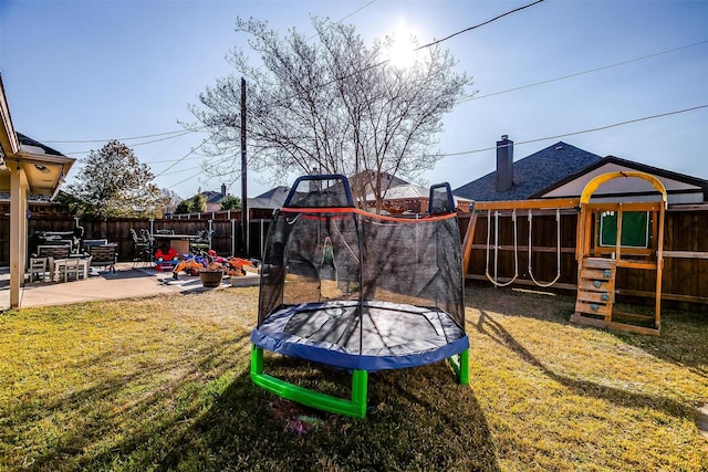 view of yard featuring a trampoline, a patio area, and a playground